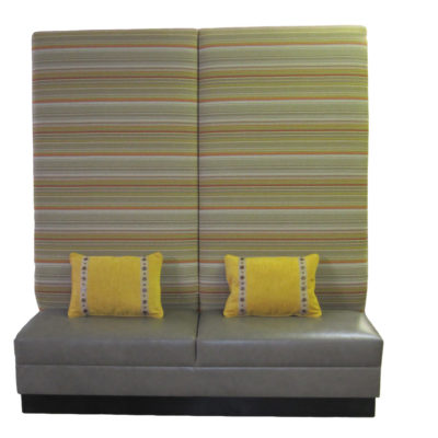 Gray upholstered seat with high back covered in striped muted colors of yellow, green, and orange; Hico Banquette