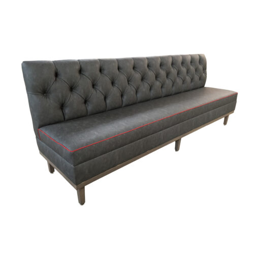 Gray upholstered Lampasas banquette with tufted back metal legs and red welting on seat